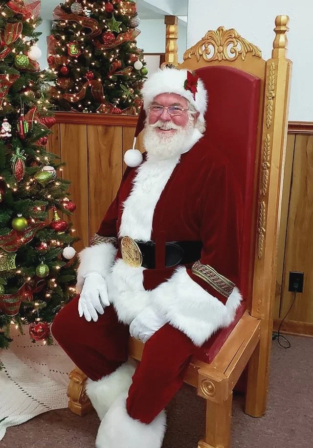 Real-bearded Santa John of Georgia Sitting in a Chair ready to visit with children.